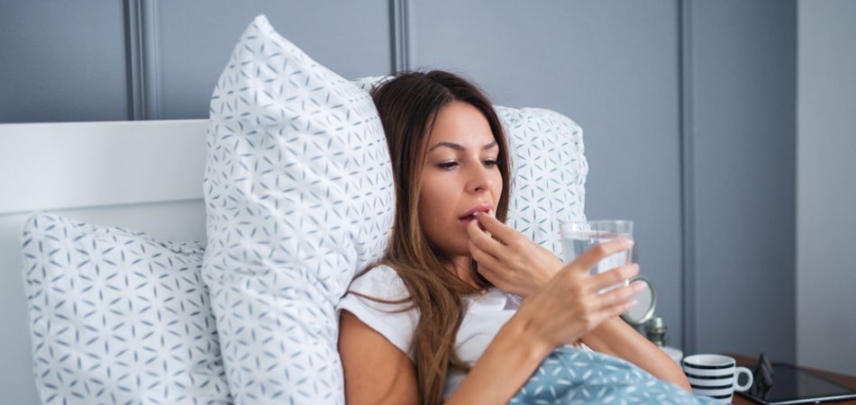 Young woman taking sleeping pill