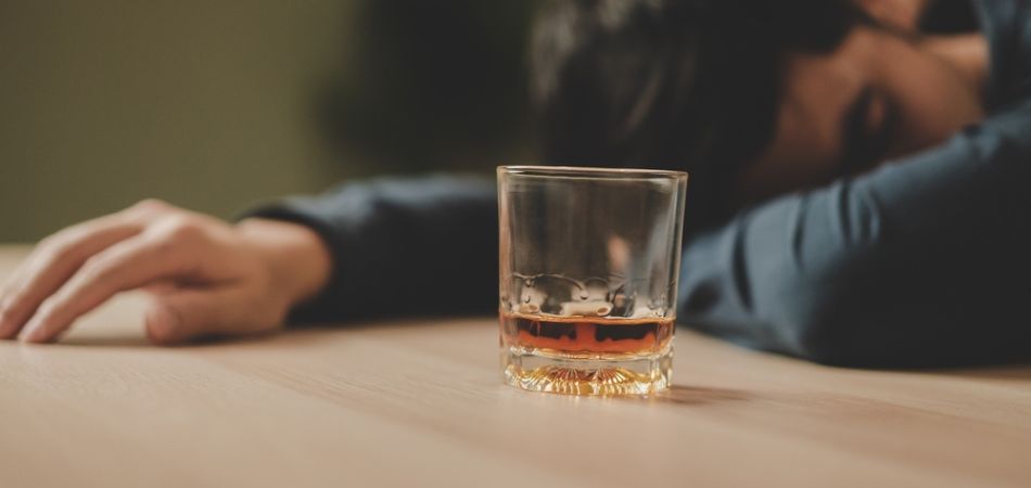 young man sleeping in alcohol addiction